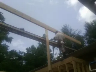 Carpenter setting a ridge beam over a new addition frame — Ice Dam Removal by Roofing Brothers in Arkansas City