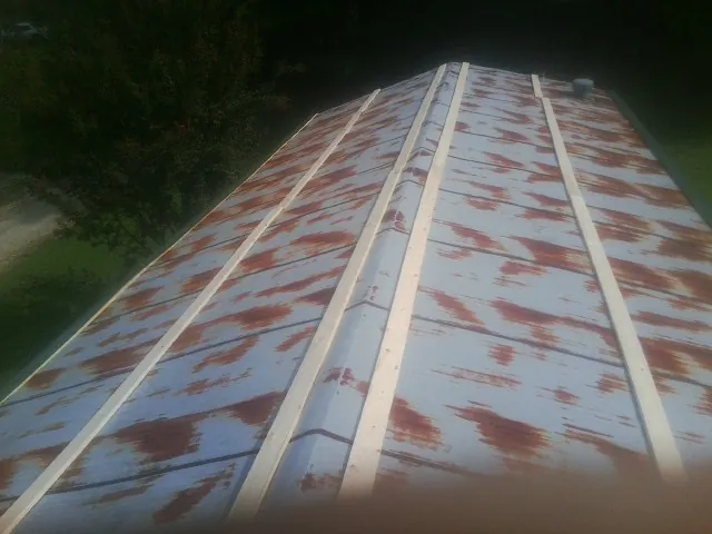 Rusted metal roof panels with new wood purlins before replacement — Storm Damage Roof Repair in Arkansas City by Roofing Brothers