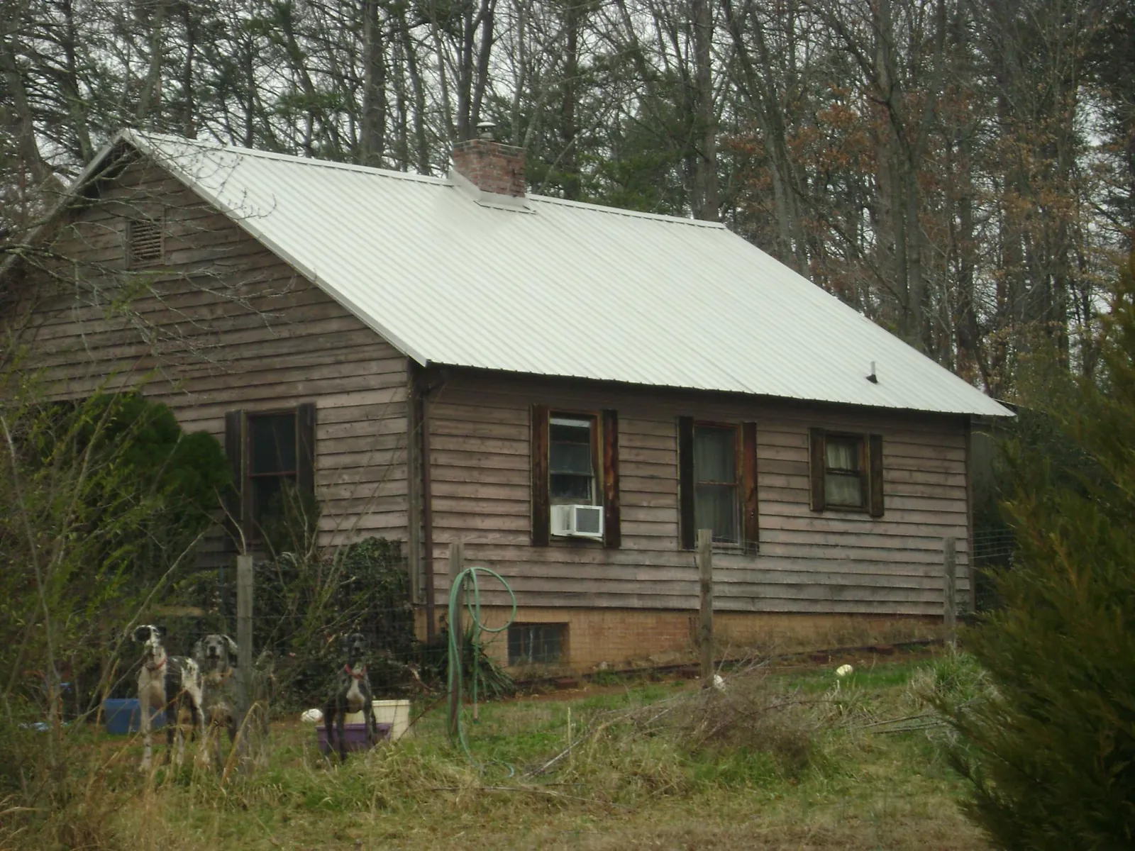 White metal roof on an old wood sided farmhouse, from a Metal Roof Installation job in Arkansas City